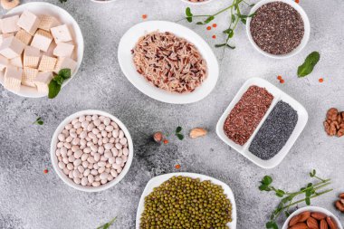 Superfoods ile kopya alanı gri bir arka plan üzerinde. Fındık, fasulye, yeşil ve tohumlar. Sağlıklı vegan gıda