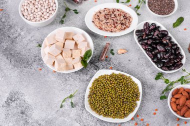 Superfoods ile kopya alanı gri bir arka plan üzerinde. Fındık, fasulye, yeşil ve tohumlar. Sağlıklı vegan gıda