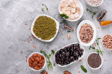 Superfoods ile kopya alanı gri bir arka plan üzerinde. Fındık, fasulye, yeşil ve tohumlar. Sağlıklı vegan gıda