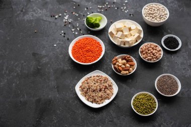 Superfoods ile kopya alanı gri bir arka plan üzerinde. Fındık, fasulye, yeşil ve tohumlar. Sağlıklı vegan gıda