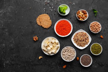 Superfoods ile kopya alanı gri bir arka plan üzerinde. Fındık, fasulye, yeşil ve tohumlar. Sağlıklı vegan gıda