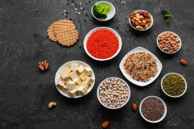 Superfoods ile kopya alanı gri bir arka plan üzerinde. Fındık, fasulye, yeşil ve tohumlar. Sağlıklı vegan gıda