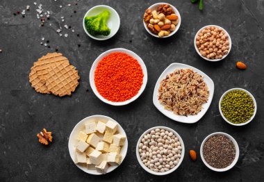 Superfoods ile kopya alanı gri bir arka plan üzerinde. Fındık, fasulye, yeşil ve tohumlar. Sağlıklı vegan gıda