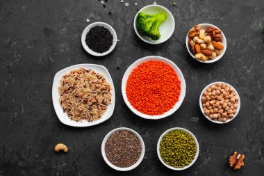 Superfoods ile kopya alanı gri bir arka plan üzerinde. Fındık, fasulye, yeşil ve tohumlar. Sağlıklı vegan gıda