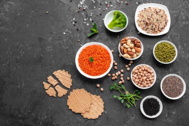 Superfoods ile kopya alanı gri bir arka plan üzerinde. Fındık, fasulye, yeşil ve tohumlar. Sağlıklı vegan gıda