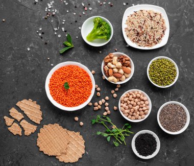 Superfoods ile kopya alanı gri bir arka plan üzerinde. Fındık, fasulye, yeşil ve tohumlar. Sağlıklı vegan gıda