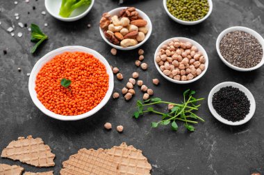 Superfoods ile kopya alanı gri bir arka plan üzerinde. Fındık, fasulye, yeşil ve tohumlar. Sağlıklı vegan gıda