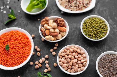 Superfoods ile kopya alanı gri bir arka plan üzerinde. Fındık, fasulye, yeşil ve tohumlar. Sağlıklı vegan gıda