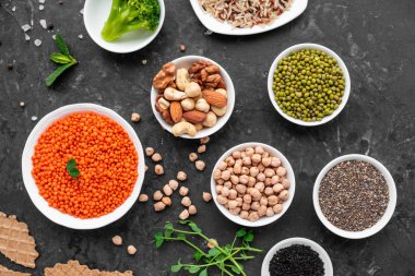 Superfoods ile kopya alanı gri bir arka plan üzerinde. Fındık, fasulye, yeşil ve tohumlar. Sağlıklı vegan gıda