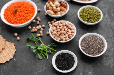 Superfoods ile kopya alanı gri bir arka plan üzerinde. Fındık, fasulye, yeşil ve tohumlar. Sağlıklı vegan gıda