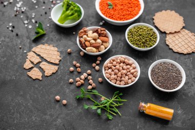 Superfoods ile kopya alanı gri bir arka plan üzerinde. Fındık, fasulye, yeşil ve tohumlar. Sağlıklı vegan gıda