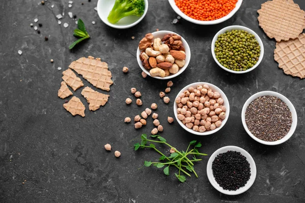 stock image Superfoods on a gray background with copy space. Nuts, beans, greens and seeds. Healthy vegan food