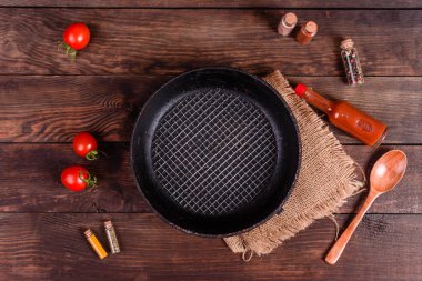 Tabak, kaşık, baharat ve koyu ahşap arka plan üzerinde diğer mutfak aksesuarları