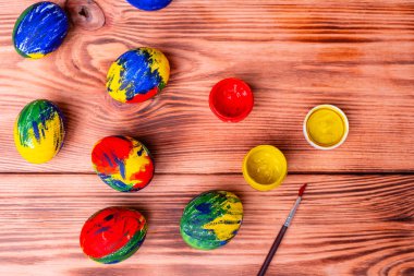 Paskalya çok renkli yumurta, boya ve fırça bir masada. Tatil için hazırlık