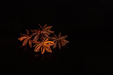 Karanlık bir arka plan aleyhine yıldız anason. Yansıma ile cam bir arka plan üzerinde Baharat