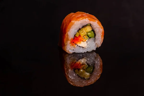 Fresh and tasty sushi on dark background. It can be used as a background