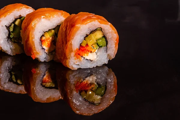 Fresh and tasty sushi on dark background. It can be used as a background