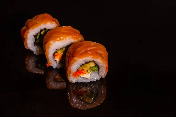 Fresh and tasty sushi on dark background. It can be used as a background