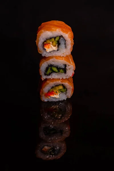 Fresh and tasty sushi on dark background. It can be used as a background