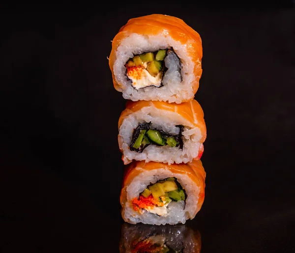 Fresh and tasty sushi on dark background. It can be used as a background