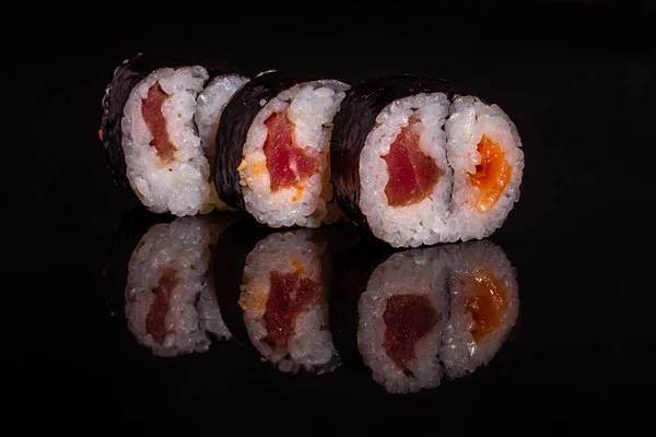 Fresh and tasty sushi on dark background. It can be used as a background