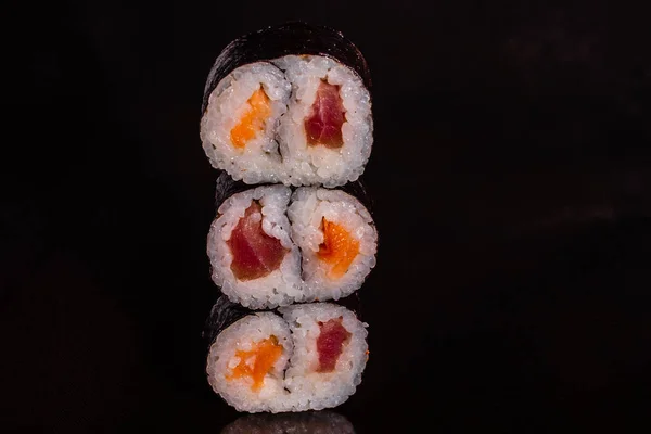 Fresh and tasty sushi on dark background. It can be used as a background