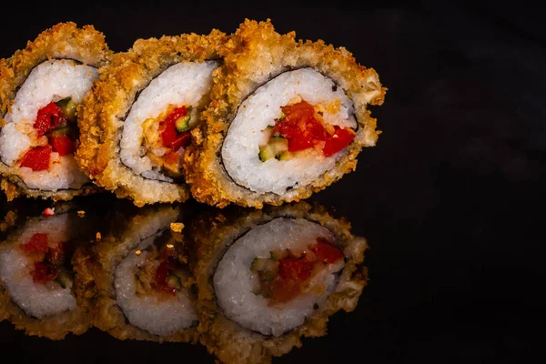 Fresh and tasty sushi on dark background. It can be used as a background