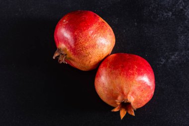 Koyu arkaplanda kırmızı nar suyu. Koyu arkaplanda yaprakları olan olgun bir nar.