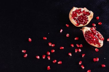 Koyu arkaplanda kırmızı nar suyu. Koyu arkaplanda yaprakları olan olgun bir nar.