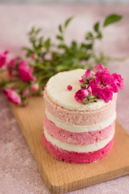 Hafif beton arka planda güzel pembe krem ve çilek kek. Doğum günü kutlama