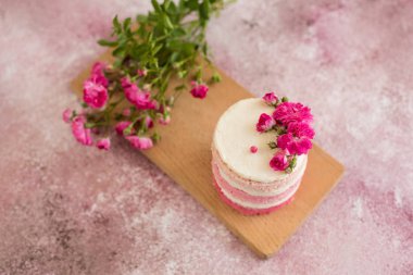 Hafif beton arka planda güzel pembe krem ve çilek kek. Doğum günü kutlama