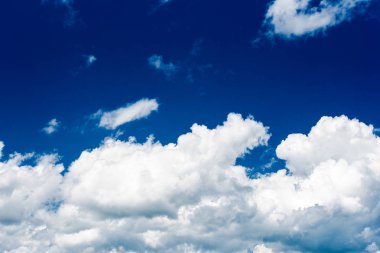 Parlak mavi gökyüzünün arka planına karşı güzel beyaz kümülonimbus bulutlar