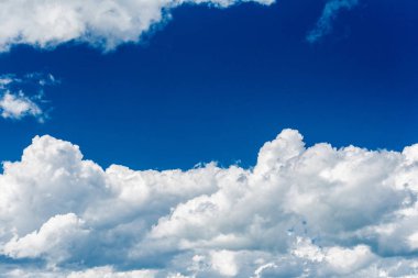 Parlak mavi gökyüzünün arka planına karşı güzel beyaz kümülonimbus bulutlar