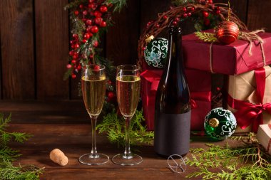 Noel tatili masası, bardaklar ve bir şişe şampanya. Yeni yıl arifesinde, hazırlık ve ahşap bir tatil masası döşeme