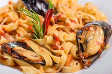 Midye ile ev yapımı makarna, kıyılmış maydanoz ve fesleğen serpin. Midye ile makarna lezzetli