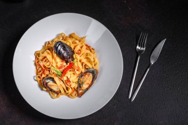 Midye ile ev yapımı makarna, kıyılmış maydanoz ve fesleğen serpin. Midye ile makarna lezzetli