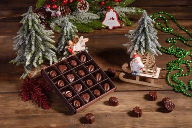 Çikolata çeşitleri, beyaz, siyah ve sütlü arkaplan şekerleri. Noel içi hediye kutuları ve Noel ateşleriyle dolu.