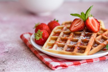 Lezzetli taze Belçika waffleları. Beton bir arka planda böğürtlen ve meyve var.