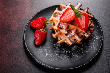 Lezzetli taze Belçika waffleları. Beton bir arka planda böğürtlen ve meyve var.