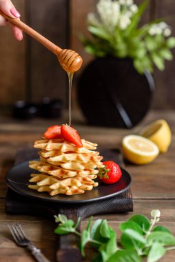 Lezzetli taze Belçika waffleları. Beton bir arka planda böğürtlen ve meyve var.