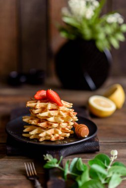 Lezzetli taze Belçika waffleları. Beton bir arka planda böğürtlen ve meyve var.