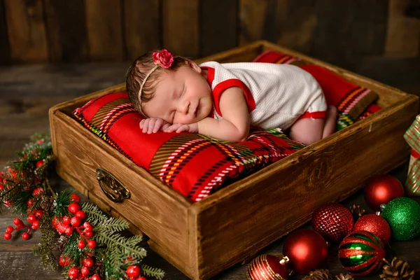 Yeni doğmuş küçük kız sekiz günlük Noel elbisesi içinde güzel bir şekilde uyuyor.
