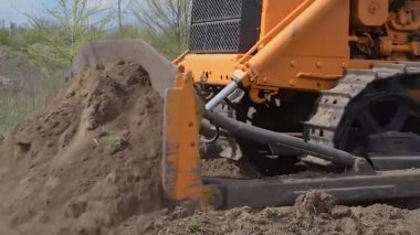 Endüstriyel inşaat alanı buldozer otoyol inşaatı sırasında toprağı düzleştiriyor ve hareket ettiriyor. İğrenç bir şantiyede sarı buldozer.