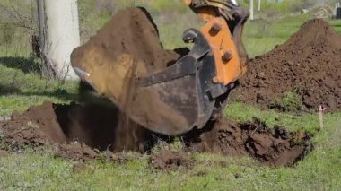 Mavi gökyüzüne karşı bir inşaat alanında sarı kazıcı. Modern kazıcı inşaat alanında kazı çalışması yapıyor.