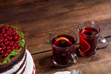 Noel masasının üzerinde parlak kırmızı böğürtlenler ve baharatlı mis kokulu şarapla nefis lezzetli bir pasta.