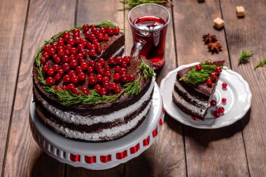 Noel masasının üzerinde parlak kırmızı böğürtlenler ve baharatlı mis kokulu şarapla nefis lezzetli bir pasta.