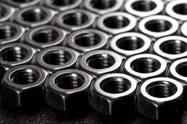 Metal çelik fındıklar siyah bir zemine yerleştirilmiş.