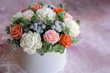 Hediye silindirik karton bir kutuda güzel, parlak gül çiçekleri. Bir buket sabun çiçeği.