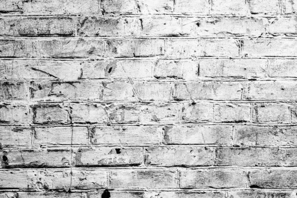 Hasarlı beyaz boya katmanlı eski tuğla duvar, yakın plan fotoğraf dokusu