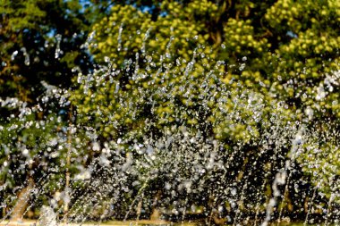 Su çeşmesinden gelen bulanık damlalar, sönmüş ışık, bulanık bokeh